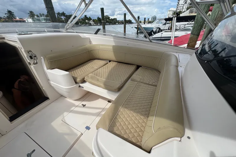 Slide: The Image of 2008 Intrepid 370 Cuddy boat interior with beige cushioned seating and waterfront view. - 37