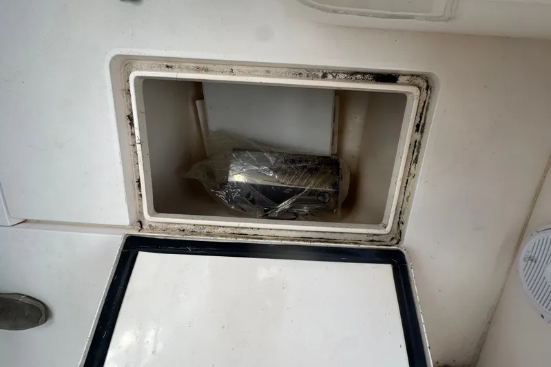 Slide: The Image of Storage compartment on a 2008 Intrepid 370 Cuddy boat, containing a wrapped item. - 40