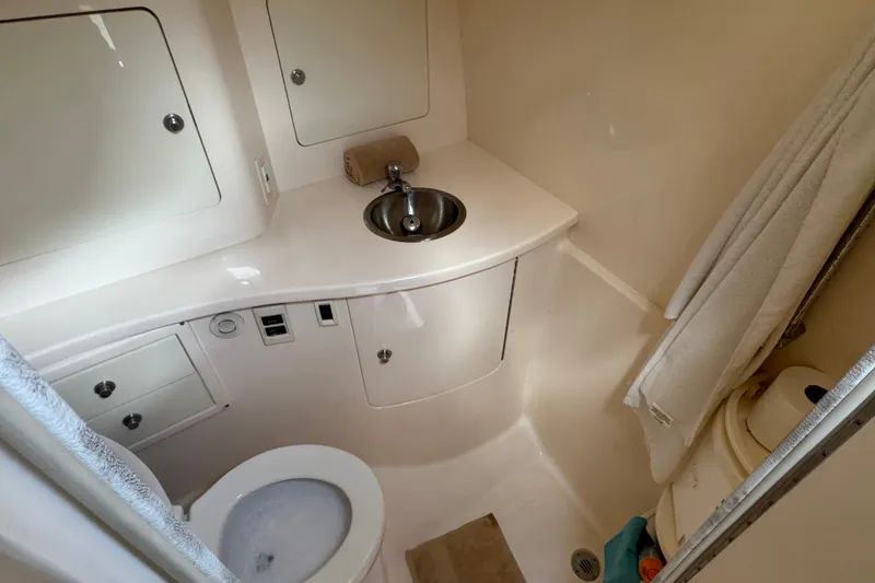 Slide: The Image of Compact bathroom in a 2008 Intrepid 370 Cuddy boat, featuring sink and toilet. - 61