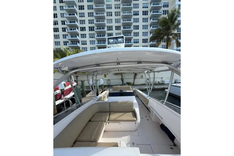 Slide: The Image of 2008 Intrepid 370 Cuddy boat interior with seating, docked near waterfront buildings. - 34
