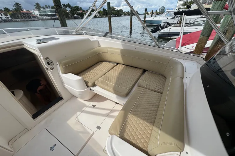 Slide: The Image of 2008 Intrepid 370 Cuddy boat interior with beige seating and waterfront view. - 38