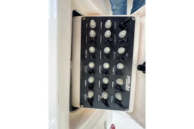Slide: The Image of Control panel of a 2008 Intrepid 370 Cuddy boat with labeled switches. - 64