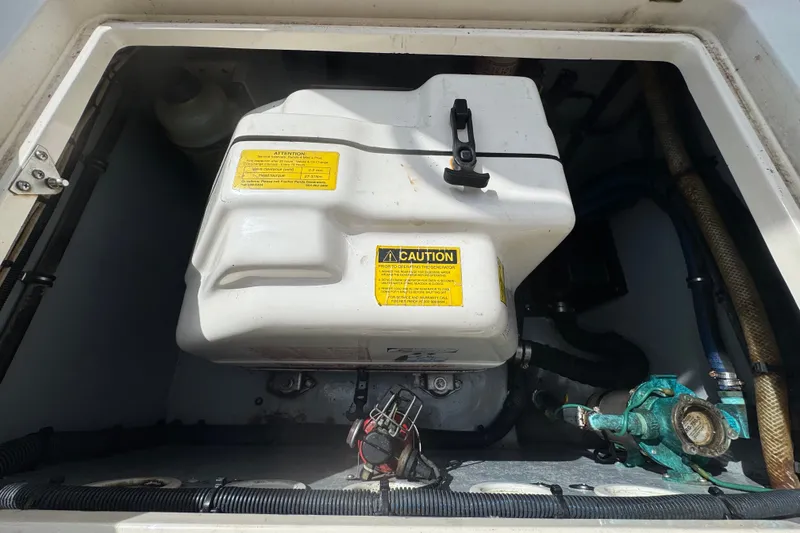Slide: The Image of Engine compartment of a 2008 Intrepid 370 Cuddy boat, featuring a white tank and caution labels. - 15