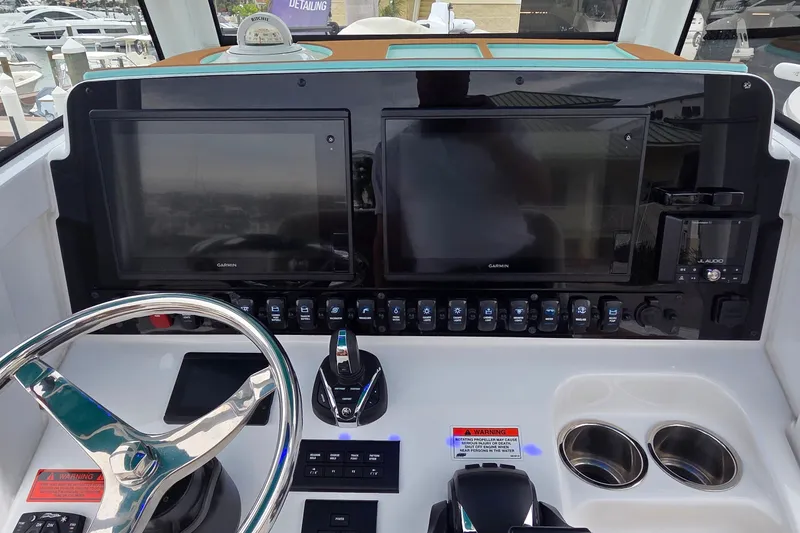 Slide: The Image of 2021 Sea Hunt Gamefish 27CB helm with dual Garmin displays and modern controls. - 20