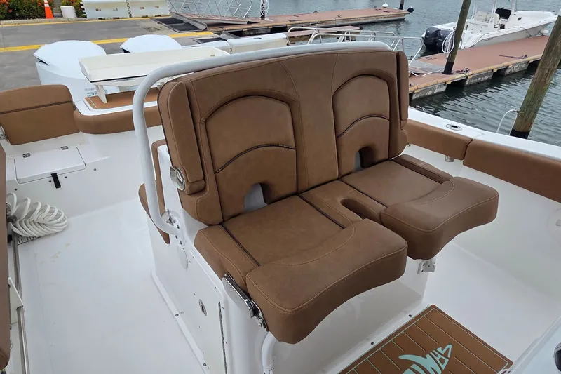 Slide: The Image of 2021 Sea Hunt Gamefish 27CB boat with brown cushioned seating at the dock. - 15