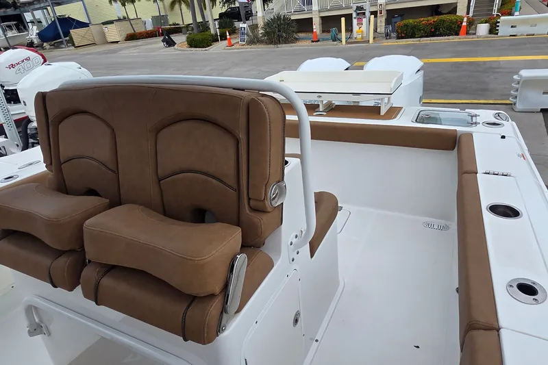 Slide: The Image of 2021 Sea Hunt Gamefish 27CB boat interior with brown seating and white deck. - 16