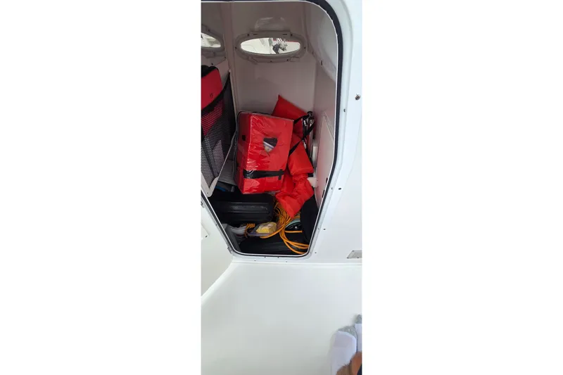 Slide: The Image of Storage compartment of 2021 Sea Hunt Gamefish 27CB with life jackets and equipment. - 17