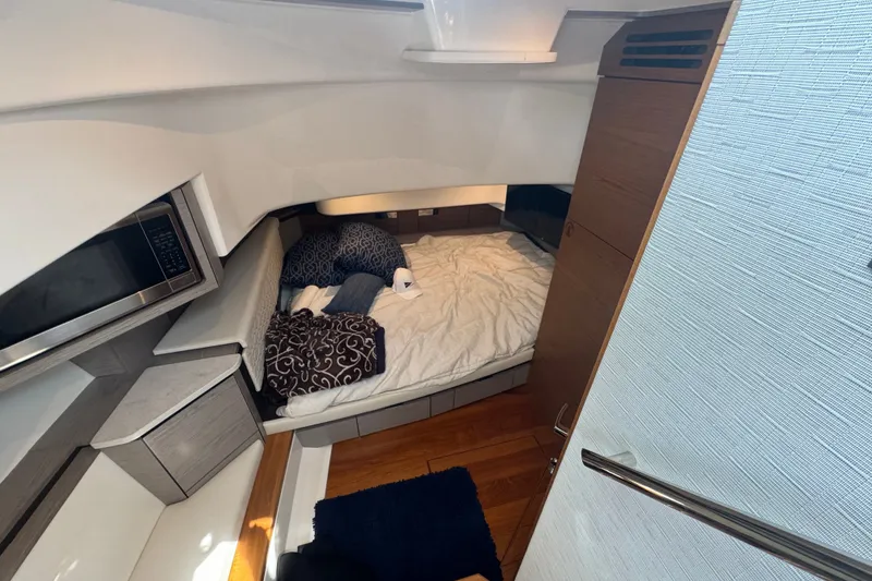 Slide: The Image of 2022 Tiara Yachts 43 LS cabin interior with bed, microwave, and modern design. - 19