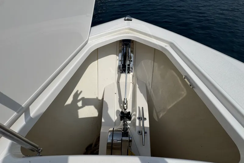 Slide: The Image of Anchor compartment of 2022 Tiara Yachts 43 LS, open hatch, calm water background. - 14