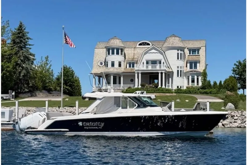 The Image of 2022 Tiara Yachts 43 LS docked near a luxurious waterfront mansion. - 0