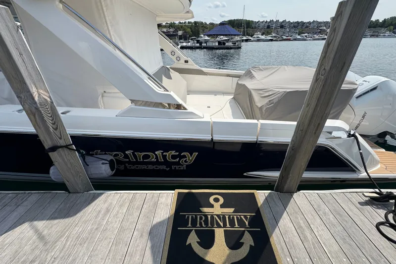 Slide: The Image of 2022 Tiara Yachts 43 LS docked, featuring "Trinity" branding and scenic marina backdrop. - 1