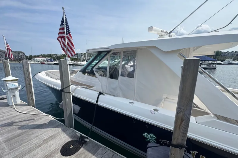 Slide: The Image of 2022 Tiara Yachts 43 LS docked, featuring sleek design and American flags. - 26