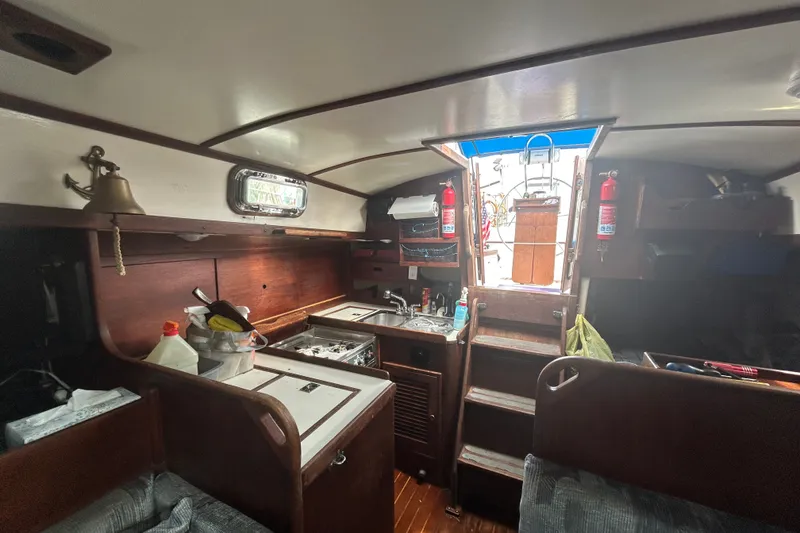 Slide: The Image of Interior of a 1979 Tartan 37 sailboat featuring a compact kitchen and wooden cabinetry. - 29