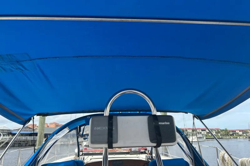 Slide: The Image of Cockpit view of a 1979 Tartan 37 sailboat with blue canopy and marina background. - 16
