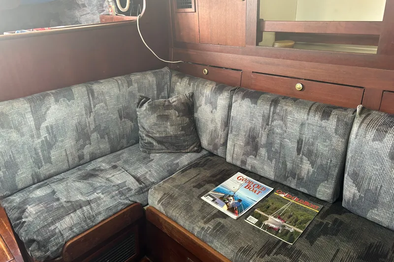 Slide: The Image of Interior of a 1979 Tartan 37 sailboat with patterned cushions and magazines on the seat. - 24