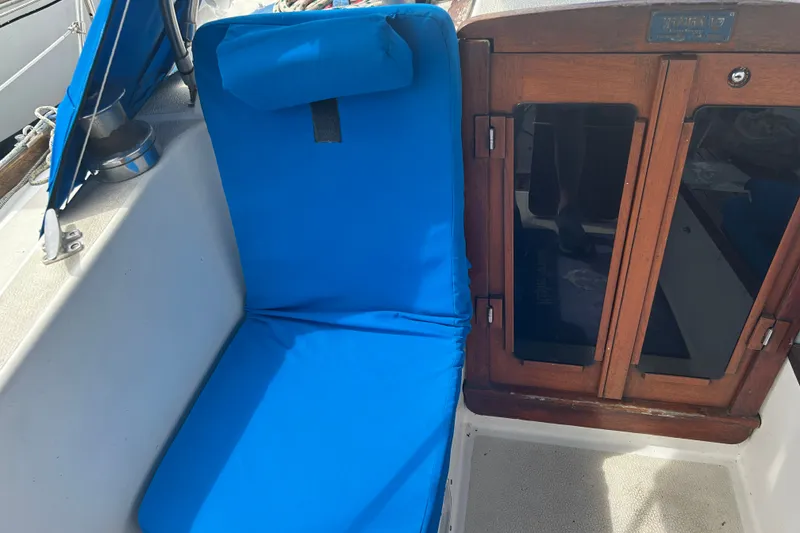 Slide: The Image of Blue cushioned seating on a 1979 Tartan 37 sailboat with wooden cabin doors. - 18