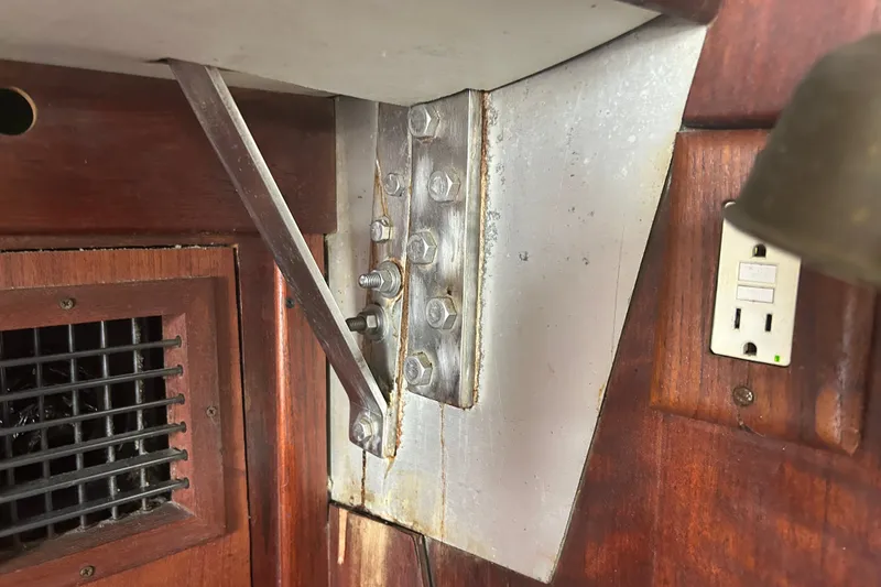 Slide: The Image of Interior detail of a 1979 Tartan 37 sailboat, featuring metal support and wooden paneling. - 48