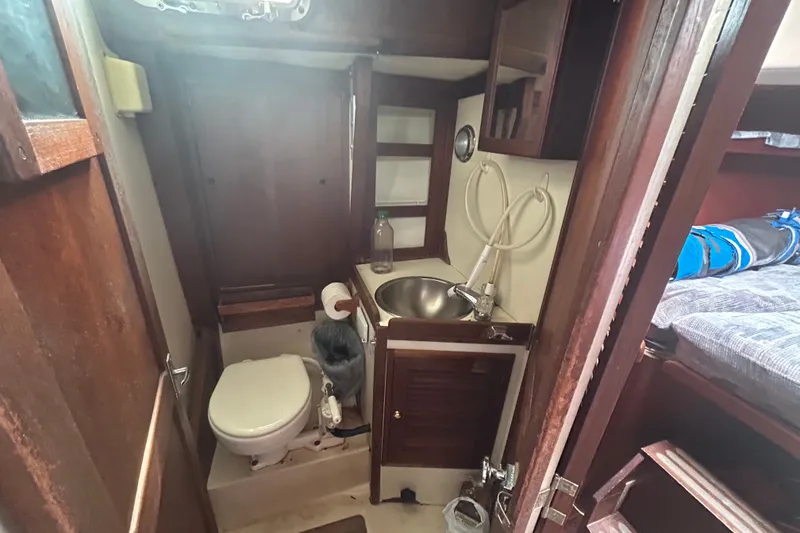 Slide: The Image of 1979 Tartan 37 sailboat bathroom with sink, toilet, and wooden cabinetry. - 30