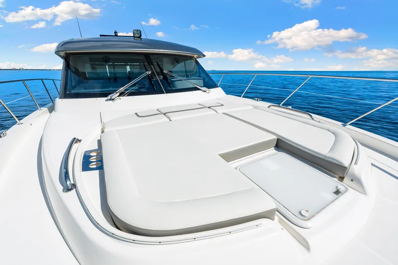 Slide: The Image of 2024 Riviera 4600 Sport Yacht Platinum Edition on open sea under blue sky. - 35