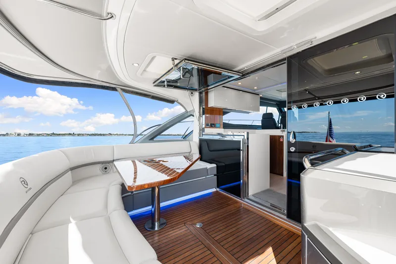 Slide: The Image of 2024 Riviera 4600 Sport Yacht Platinum Edition interior with luxurious seating and ocean view. - 40