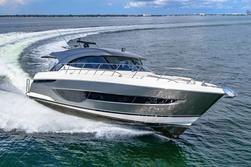 Slide: The Image of 2024 Riviera 4600 Sport Yacht Platinum Edition cruising on open water. - 17