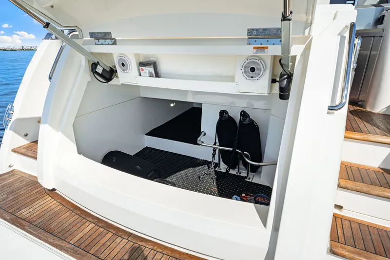 Slide: The Image of 2024 Riviera 4600 Sport Yacht Platinum Edition storage compartment with diving gear and speakers. - 24