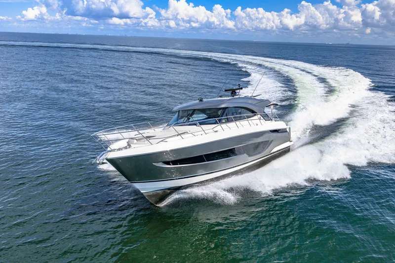 Slide: The Image of 2024 Riviera 4600 Sport Yacht Platinum Edition cruising on open water. - 19
