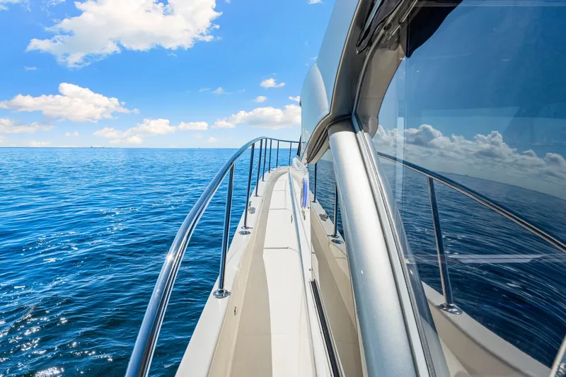 Slide: The Image of 2024 Riviera 4600 Sport Yacht Platinum Edition cruising on open sea under blue sky. - 32