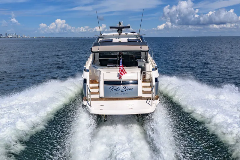 Slide: The Image of 2024 Riviera 4600 Sport Yacht Platinum Edition cruising on open water, rear view. - 18