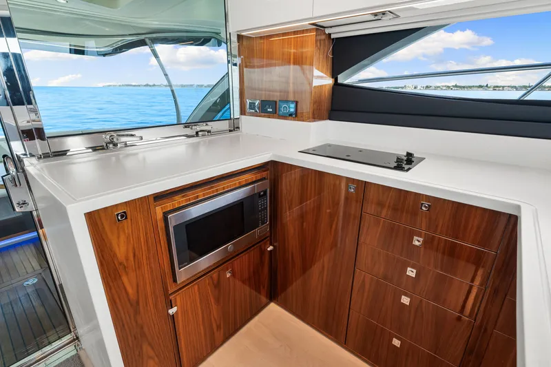 Slide: The Image of Luxurious kitchen interior of 2024 Riviera 4600 Sport Yacht Platinum Edition with wood cabinetry. - 46