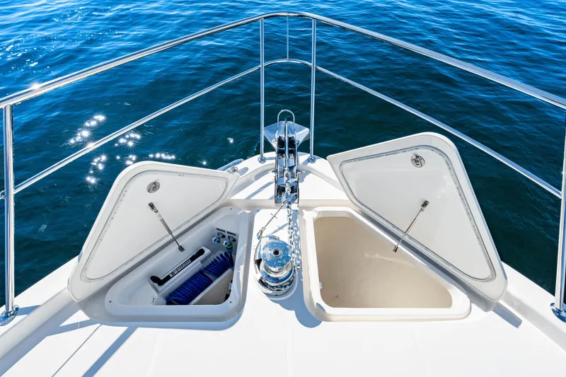 Slide: The Image of 2024 Riviera 4600 Sport Yacht Platinum Edition bow with open storage compartments. - 38