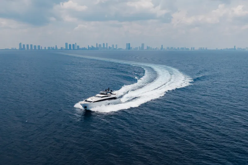 Slide: The Image of 2024 Sanlorenzo SL90A yacht cruising on open sea with city skyline in background. - 18