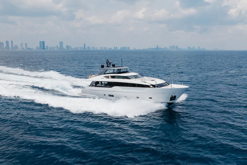 Slide: The Image of 2024 Sanlorenzo SL90A yacht cruising on open sea with city skyline in background. - 16