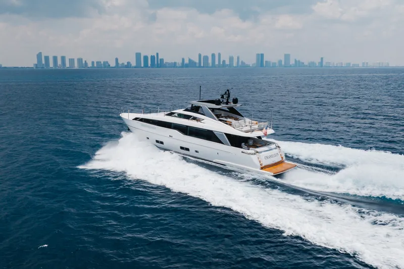 Slide: The Image of 2024 Sanlorenzo SL90A yacht cruising on open sea with city skyline backdrop. - 23