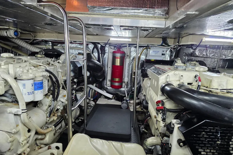 Slide: The Image of Engine room of 2001 Cruisers Yachts 4450 Express Motoryacht, featuring dual engines and fire extinguisher. - 26