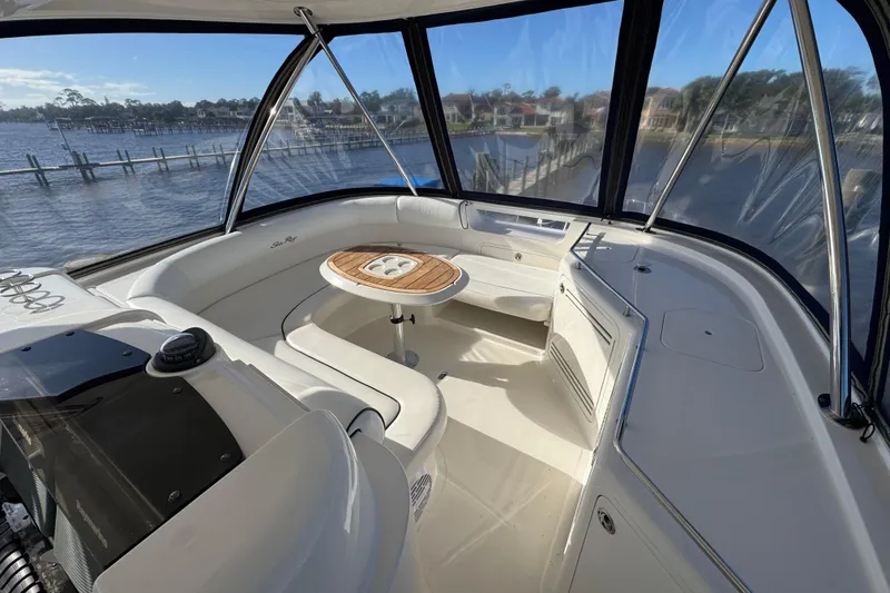 Slide: The Image of 2007 Sea Ray 58 Sedan Bridge interior with seating and table, overlooking marina. - 16
