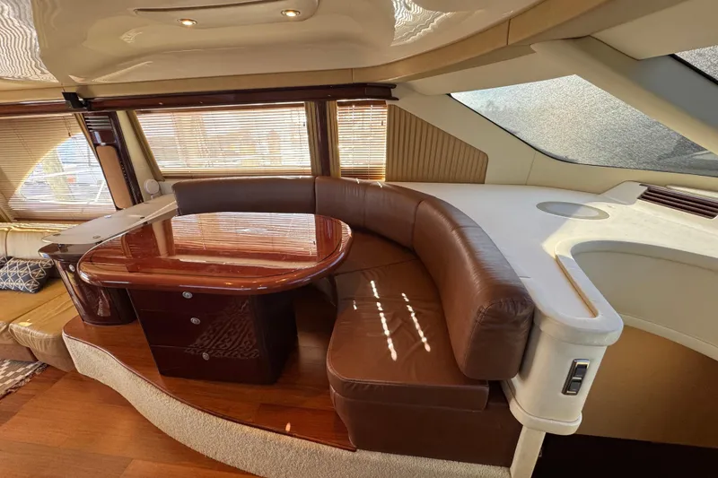 Slide: The Image of Luxurious interior of a 2007 Sea Ray 58 Sedan Bridge yacht with leather seating and wooden table. - 32