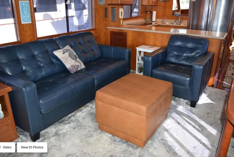 Slide: The Image of Luxurious interior of 2002 Grand Alaskan Cockpit Motor Yacht with blue seating and brown ottoman. - 15