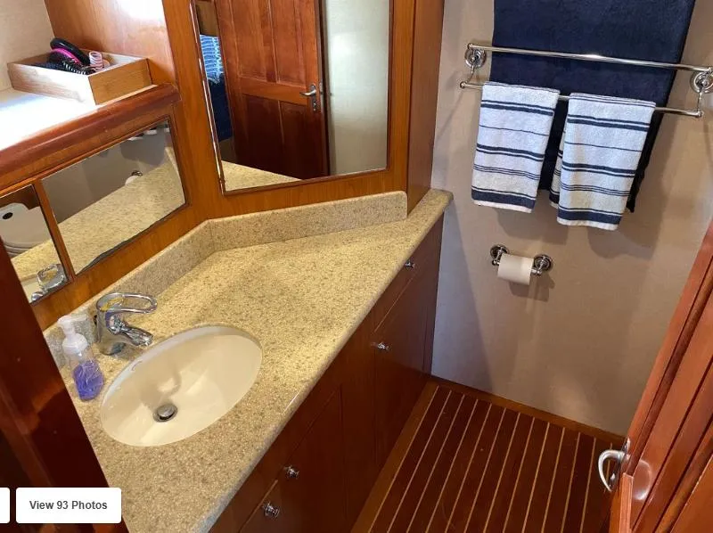 Slide: The Image of Luxurious bathroom in 2002 Grand Alaskan Cockpit Motor Yacht with granite countertop and wooden accents. - 38
