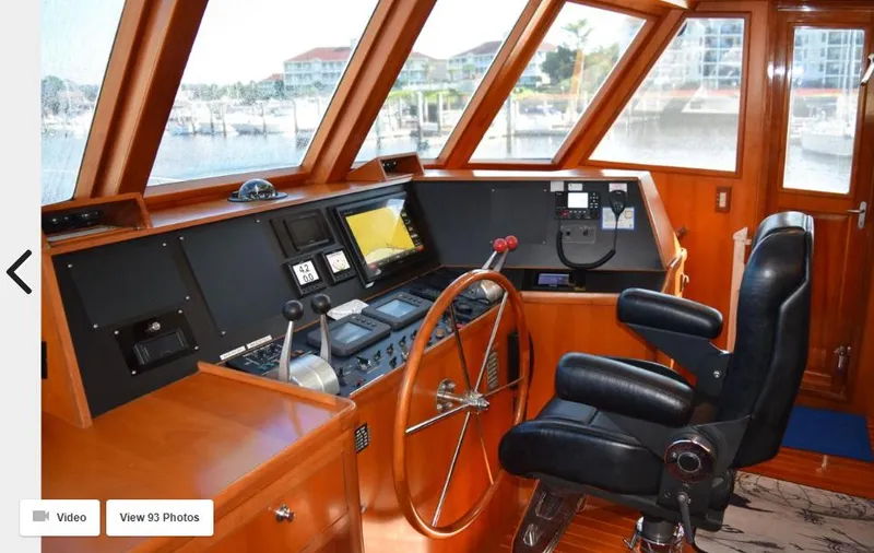 Slide: The Image of Cockpit of 2002 Grand Alaskan Motor Yacht with navigation controls and leather captain's chair. - 9