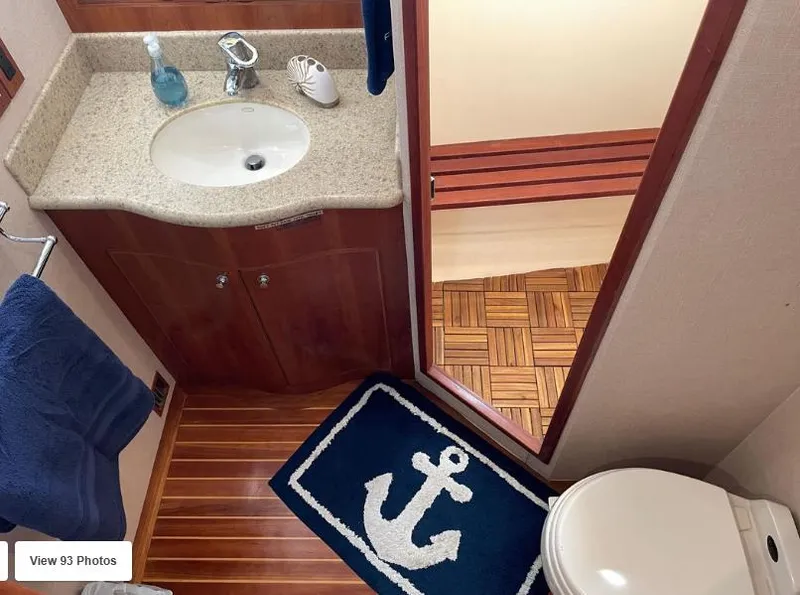 Slide: The Image of 2002 Grand Alaskan Cockpit Motor Yacht bathroom with anchor-themed decor and wooden flooring. - 43