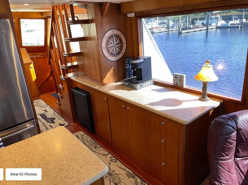 Slide: The Image of Luxurious 2002 Grand Alaskan Cockpit Motor Yacht interior with wood cabinetry and waterfront view. - 17