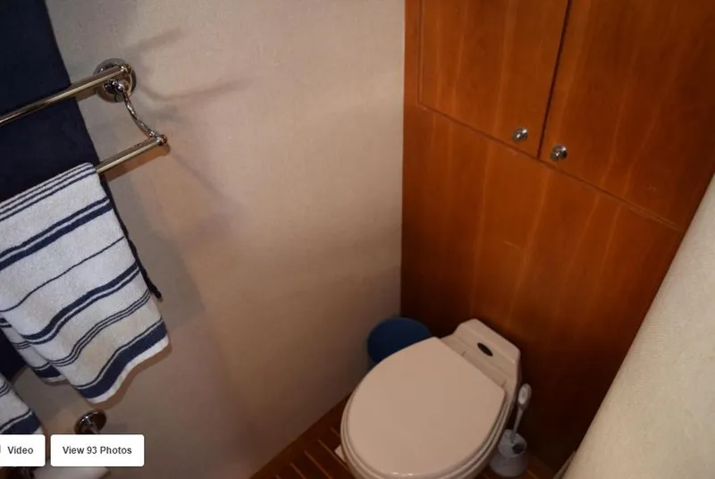Slide: The Image of Bathroom interior of 2002 Grand Alaskan Cockpit Motor Yacht with wooden cabinets and towel rack. - 39