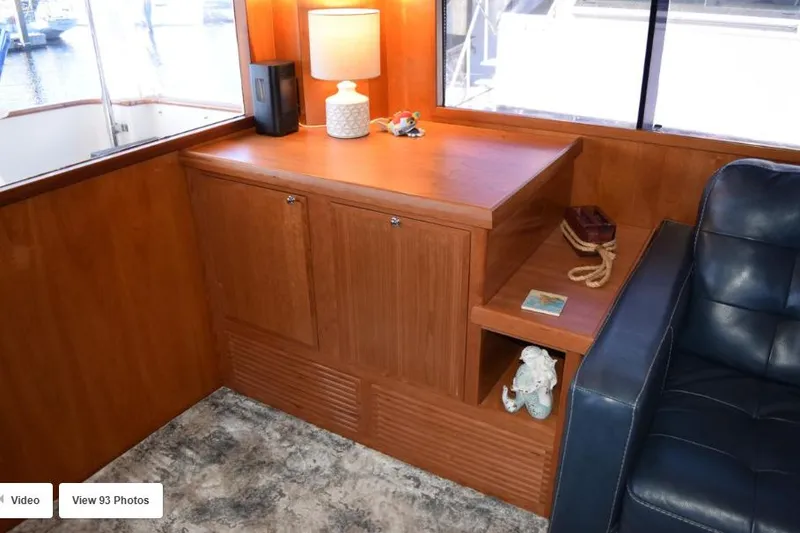 Slide: The Image of Interior of 2002 Grand Alaskan Cockpit Motor Yacht with wooden cabinetry and leather seating. - 19