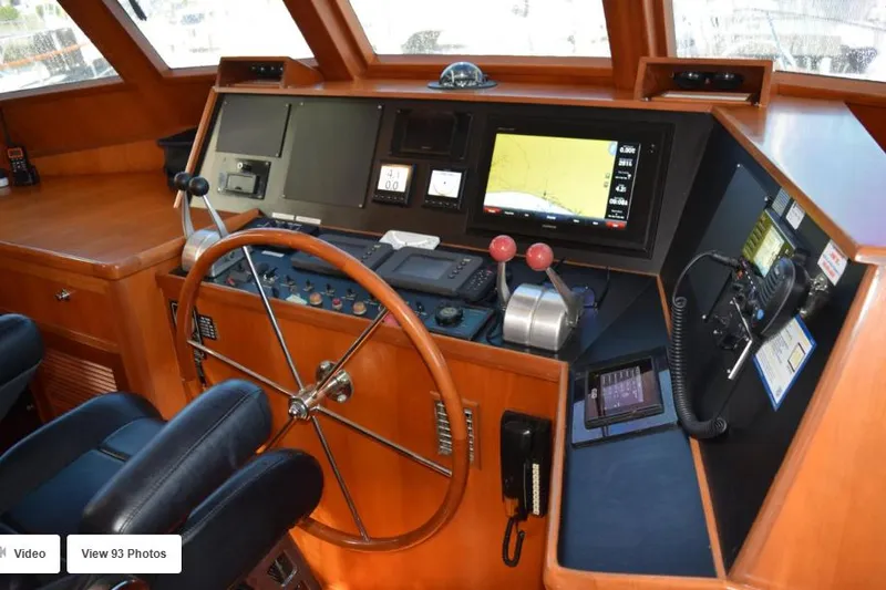 Slide: The Image of 2002 Grand Alaskan Cockpit Motor Yacht helm with navigation equipment and wooden steering wheel. - 10