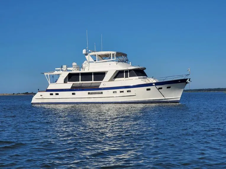 Slide: The Image of 2002 Grand Alaskan Cockpit Motor Yacht on calm water under clear blue sky. - 1