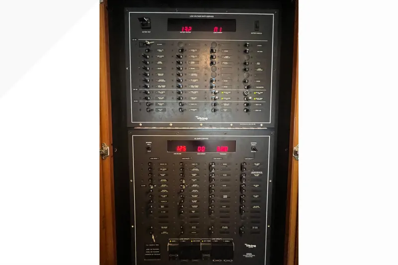 Slide: The Image of Electrical control panel of a 1999 Viking 60 CPMY yacht, featuring various switches and displays. - 63