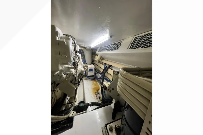 Slide: The Image of Engine room of 1999 Viking 60 CPMY yacht, showcasing mechanical components and piping. - 141
