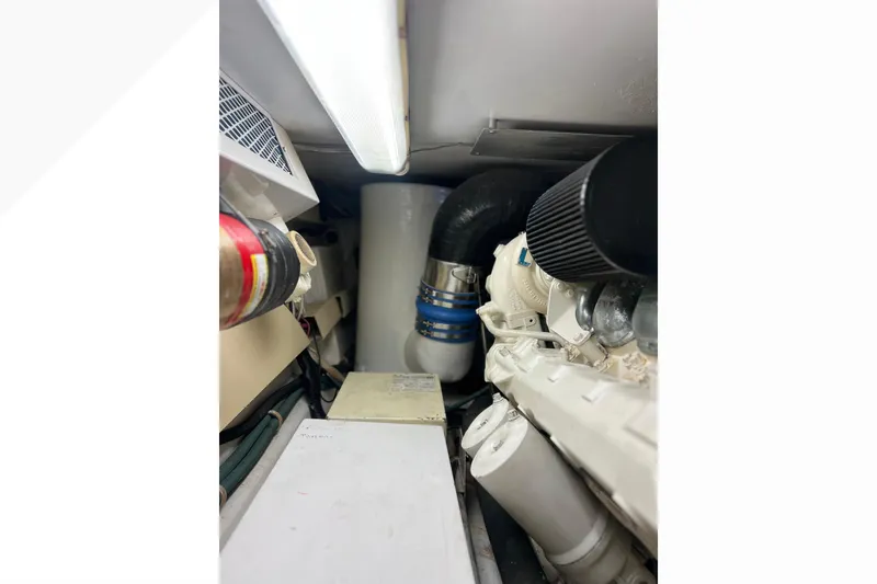 Slide: The Image of Engine room of 1999 Viking 60 CPMY yacht, featuring mechanical components and piping. - 147