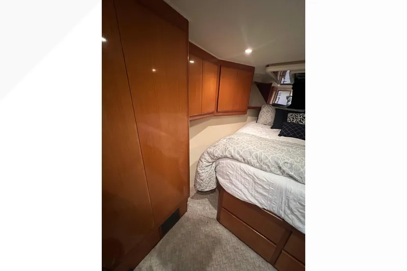 Slide: The Image of Cozy bedroom in 1999 Viking 60 CPMY yacht with wooden cabinets and plush bedding. - 84